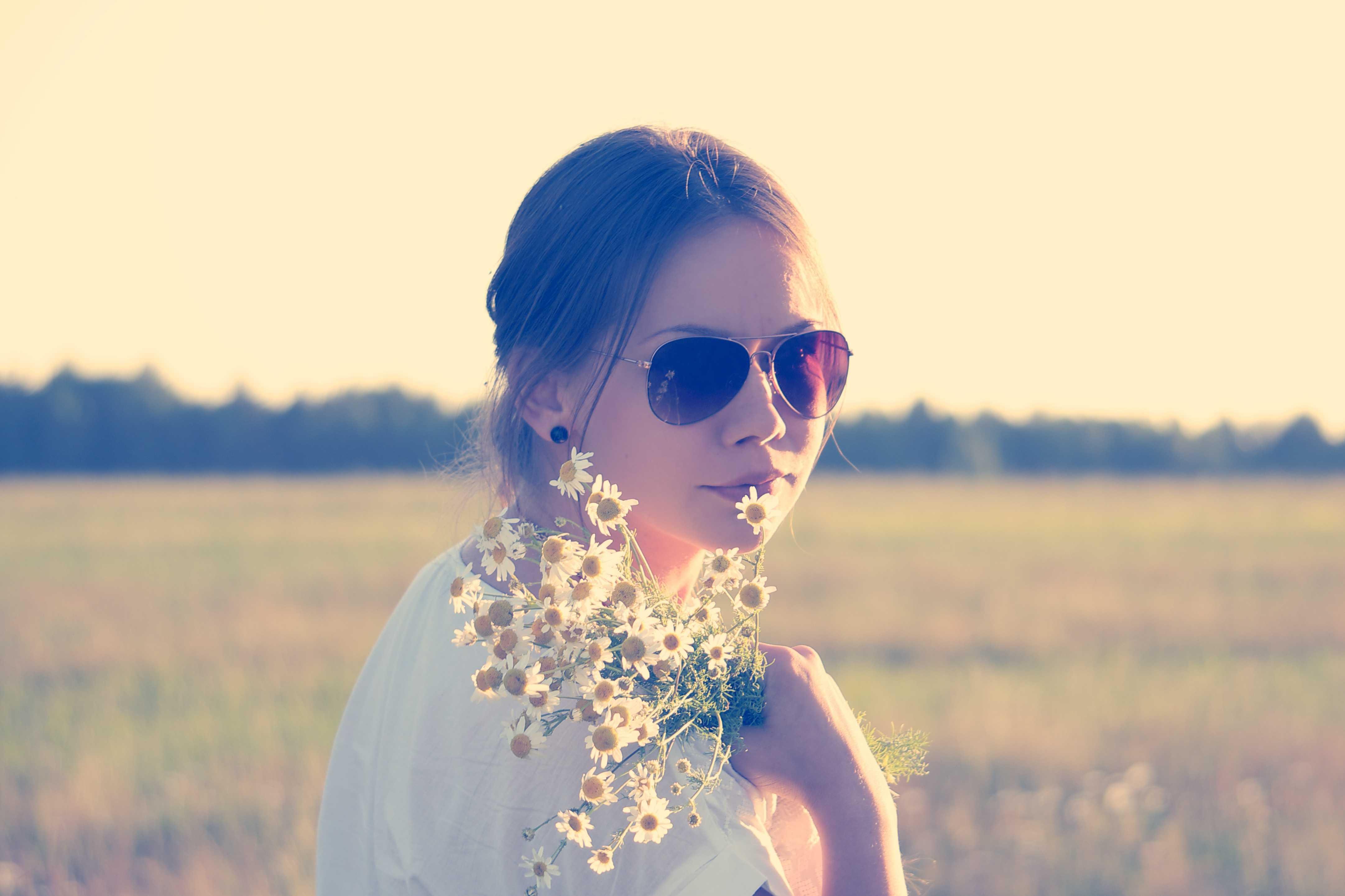 Chica con gafas y flores en las manos