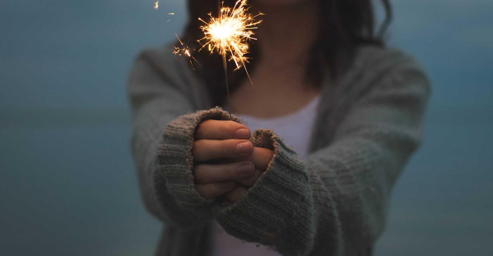 happy woman with sparkler ready to start project